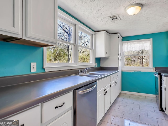 927 Dean Patrick Rd, Locust Grove, GA 30248 - kitchen featuring appliances with stainless steel finishes, white cabinetry, a sink, stainless steel counters, and a textured ceiling