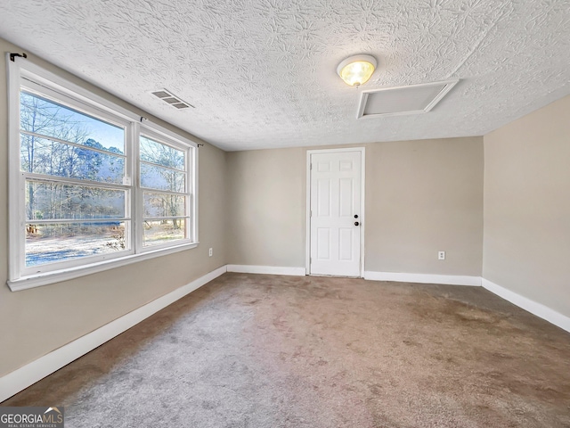 927 Dean Patrick Rd, Locust Grove, GA 30248 - empty room with plenty of natural light, a textured ceiling, baseboards, carpet, and attic access