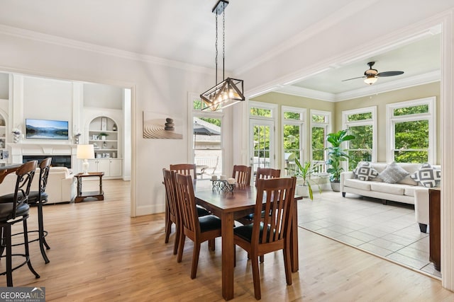 952 Moores Walk Ln, Suwanee, GA 30024 - dining space featuring crown molding, a ceiling fan, light wood-style flooring, built in features, and baseboards