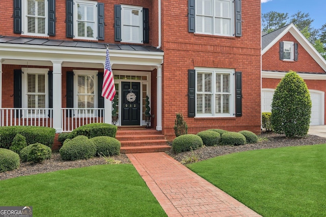 952 Moores Walk Ln, Suwanee, GA 30024 - entrance to property featuring brick siding, a lawn, covered porch, a standing seam roof, and concrete driveway