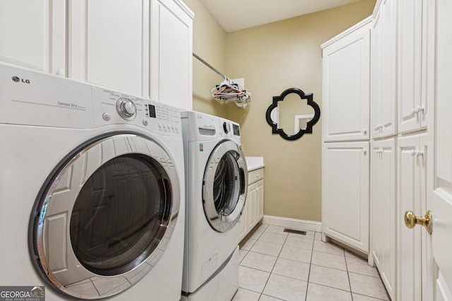 952 Moores Walk Ln, Suwanee, GA 30024 - washroom featuring cabinet space, washer and clothes dryer, light tile patterned floors, and baseboards