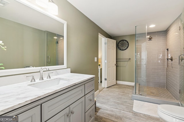 952 Moores Walk Ln, Suwanee, GA 30024 - bathroom featuring vanity, a stall shower, toilet, wood finished floors, and recessed lighting