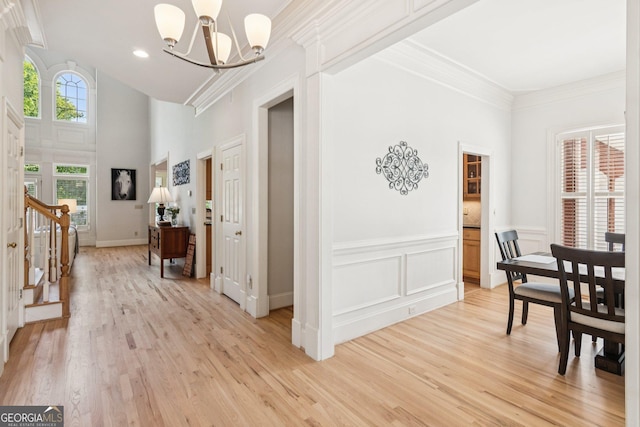 952 Moores Walk Ln, Suwanee, GA 30024 - dining space with a chandelier, light wood-type flooring, stairs, a towering ceiling, and ornamental molding