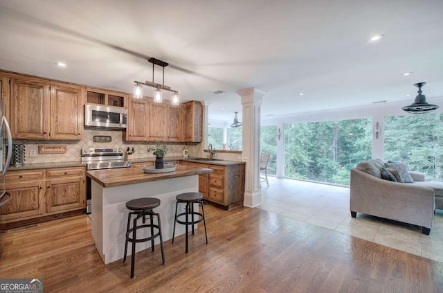 6095 Fords Rd NW, Acworth, GA 30101 - kitchen featuring appliances with stainless steel finishes, a sink, open floor plan, decorative backsplash, and a kitchen island