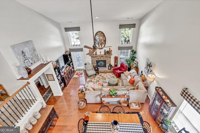 7891 Brass Lantern Dr, Flowery Branch, GA 30542 - living room with a fireplace, healthy amount of natural light, wood finished floors, and a towering ceiling
