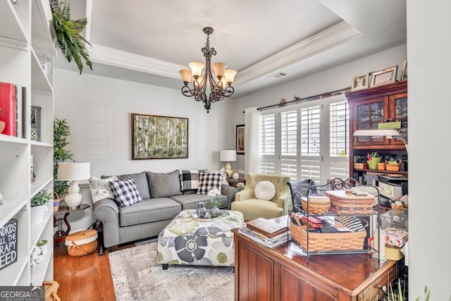 7891 Brass Lantern Dr, Flowery Branch, GA 30542 - living area featuring crown molding, a chandelier, wood finished floors, and a tray ceiling