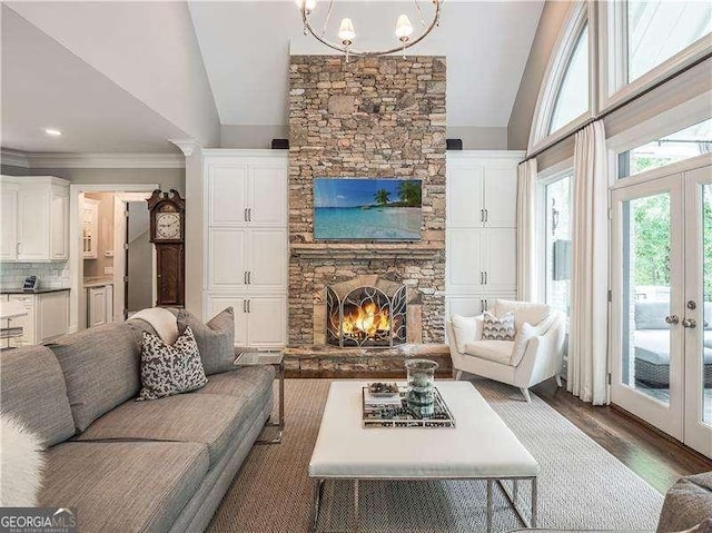 8957 Old Southwick Pass, Johns Creek, GA 30022 - living area with lofted ceiling, french doors, wood finished floors, a fireplace, and a chandelier