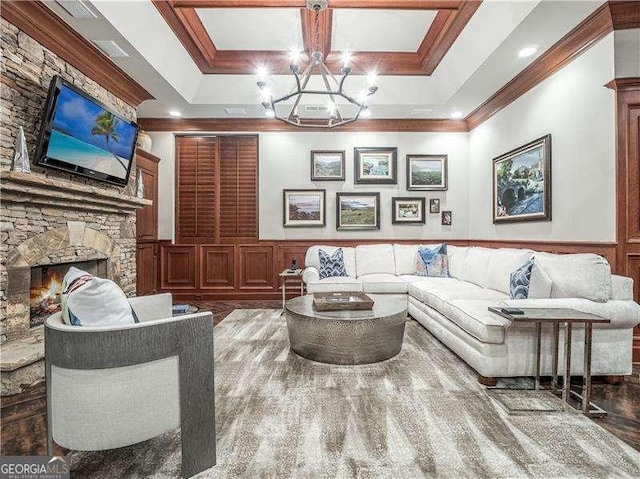 8957 Old Southwick Pass, Johns Creek, GA 30022 - living area with crown molding, a chandelier, wainscoting, a stone fireplace, and a decorative wall