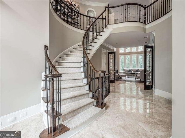 8957 Old Southwick Pass, Johns Creek, GA 30022 - staircase featuring a towering ceiling, ornamental molding, marble tiled floors, and baseboards