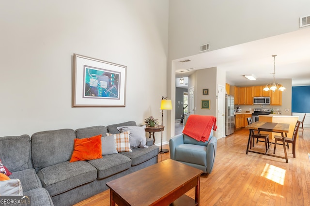 2600 Neighborhood Walk, Villa Rica, GA 30180 - living room featuring a chandelier, light wood-type flooring, and a high ceiling