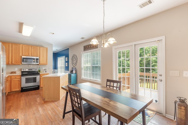 2600 Neighborhood Walk, Villa Rica, GA 30180 - kitchen with appliances with stainless steel finishes, light brown cabinets, light wood-style floors, light countertops, and a chandelier