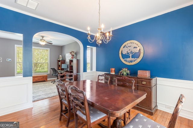 2600 Neighborhood Walk, Villa Rica, GA 30180 - dining area featuring arched walkways, wood finished floors, wainscoting, a chandelier, and ornamental molding