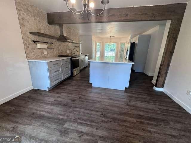 2000 Brickton Sta, Buford, GA 30518 - kitchen with a chandelier, stainless steel appliances, wall chimney range hood, and baseboards