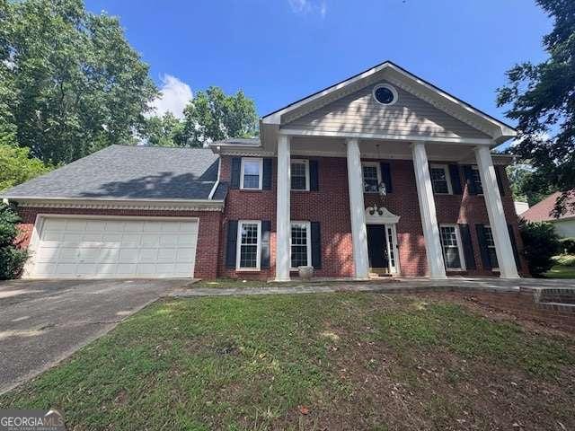 2000 Brickton Sta, Buford, GA 30518 - neoclassical / greek revival house featuring driveway, an attached garage, brick siding, and a front lawn