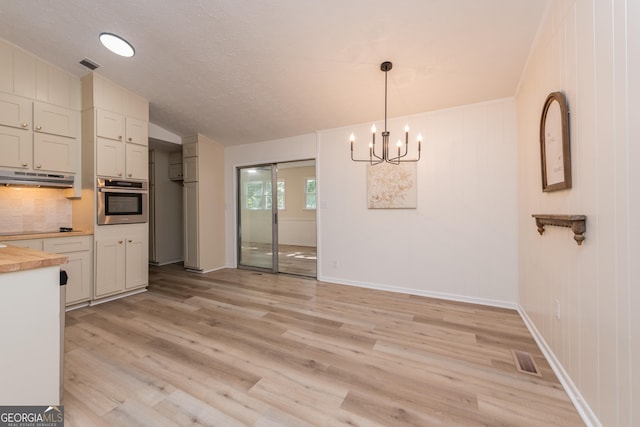 139 Old Oak Rd, Byron, GA 31008 - unfurnished dining area featuring a chandelier, light wood-style floors, baseboards, a textured ceiling, and lofted ceiling