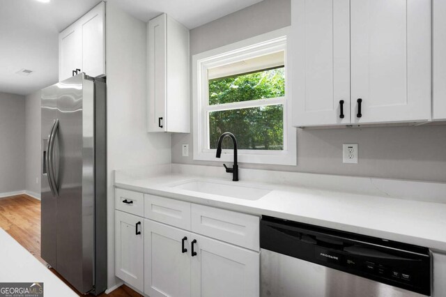 162 Langston Rd NE, Calhoun, GA 30701 - kitchen featuring appliances with stainless steel finishes, a sink, white cabinets, and light countertops