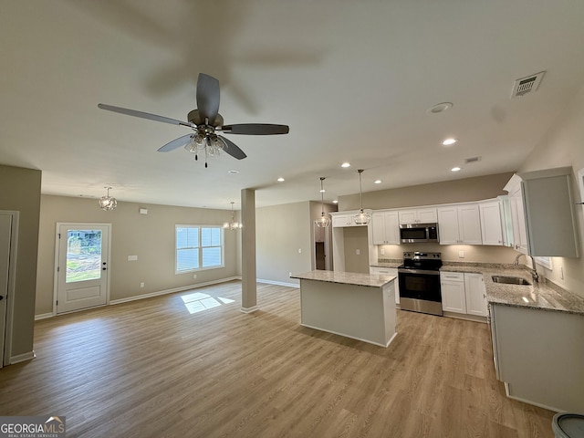 143 Roberts Quarters Rd, Concord, GA 30206 - kitchen featuring appliances with stainless steel finishes, a sink, a ceiling fan, a center island, and light wood finished floors
