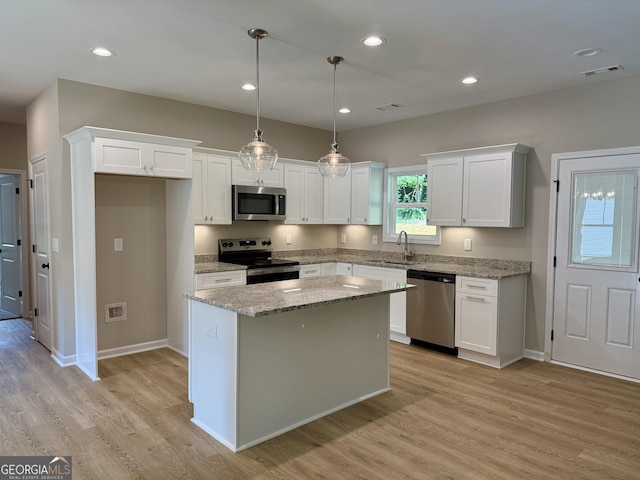 143 Roberts Quarters Rd, Concord, GA 30206 - kitchen featuring stainless steel appliances, a sink, light wood-type flooring, white cabinets, and a kitchen island