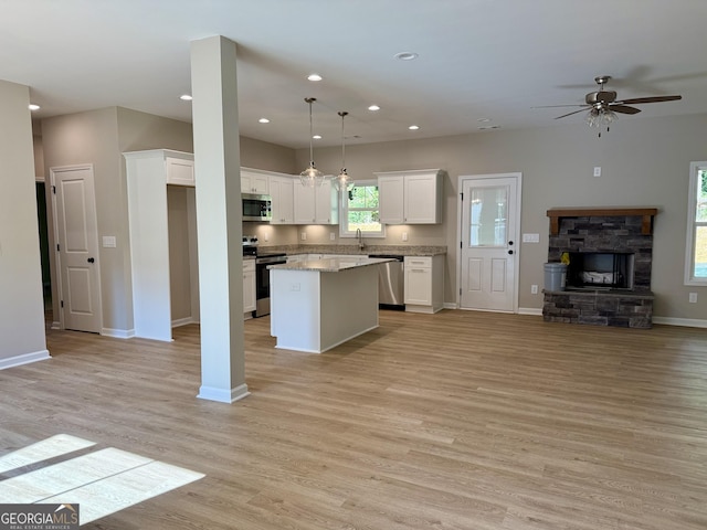 143 Roberts Quarters Rd, Concord, GA 30206 - kitchen featuring stainless steel appliances, open floor plan, light wood-type flooring, white cabinetry, and a ceiling fan