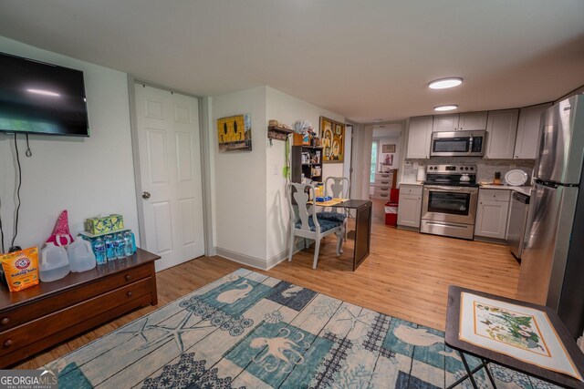 128 Branch St, Toccoa, GA 30577 - kitchen featuring appliances with stainless steel finishes, gray cabinets, light wood finished floors, backsplash, and baseboards