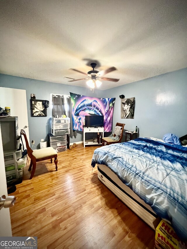 2618 Ga Highway 86, Adrian, GA 31002 - bedroom featuring wood finished floors, a textured ceiling, and a ceiling fan