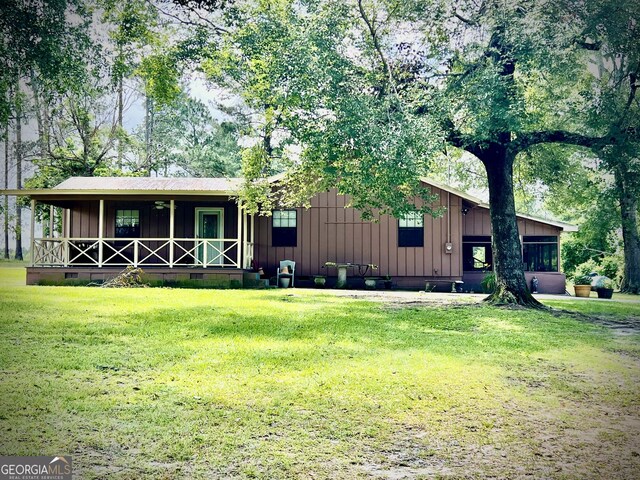 2618 Ga Highway 86, Adrian, GA 31002 - view of front of house with board and batten siding, a front yard, covered porch, and crawl space
