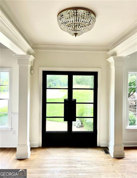 8525 Anchor On Lanier Ct, Gainesville, GA 30506 - entryway featuring ornate columns, ornamental molding, light wood finished floors, and baseboards