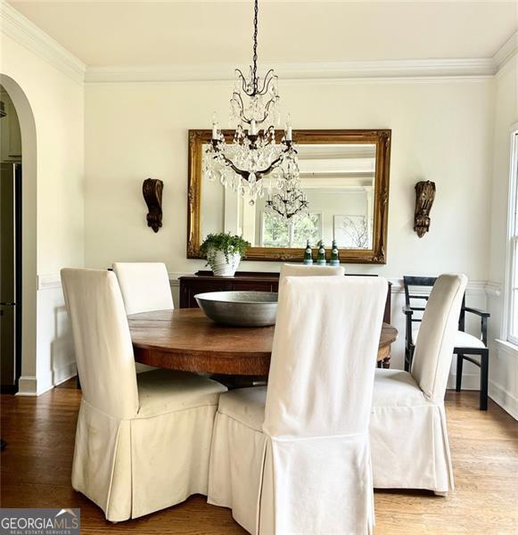 8525 Anchor On Lanier Ct, Gainesville, GA 30506 - dining room featuring a chandelier, arched walkways, wood finished floors, crown molding, and baseboards