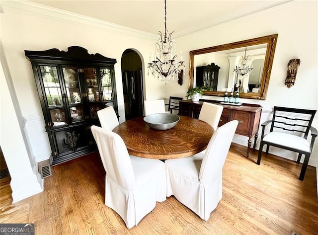 8525 Anchor On Lanier Ct, Gainesville, GA 30506 - dining room with arched walkways, light wood finished floors, crown molding, and a chandelier