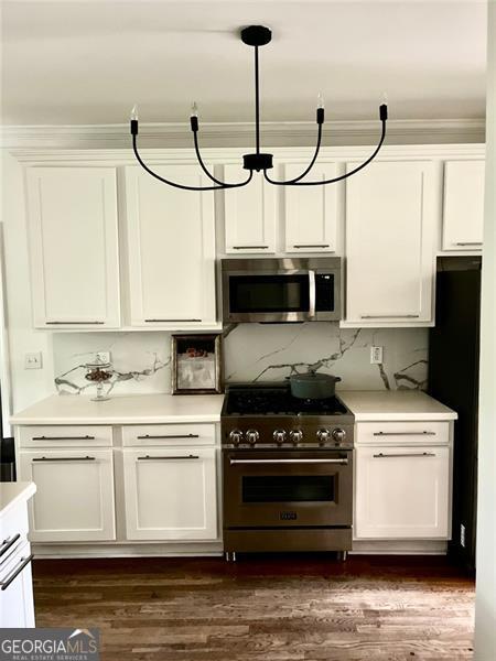 8525 Anchor On Lanier Ct, Gainesville, GA 30506 - kitchen featuring stainless steel appliances, white cabinetry, and crown molding