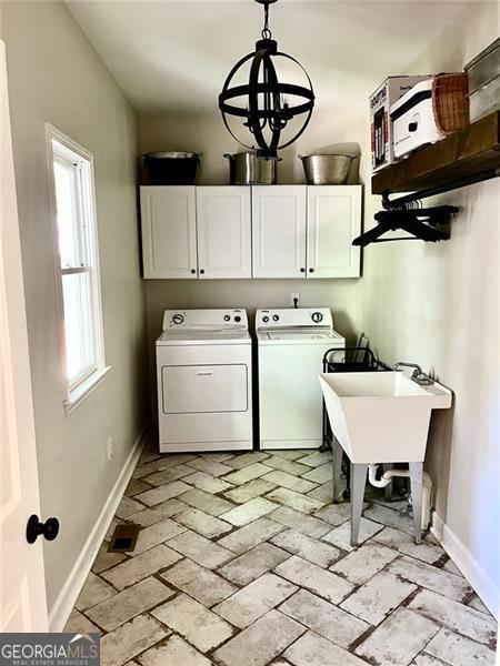 8525 Anchor On Lanier Ct, Gainesville, GA 30506 - washroom featuring cabinet space, washing machine and dryer, baseboards, and a chandelier