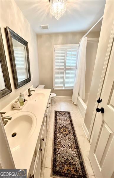 8525 Anchor On Lanier Ct, Gainesville, GA 30506 - full bathroom featuring tile patterned flooring, toilet, double vanity, shower / bath combo with shower curtain, and a chandelier