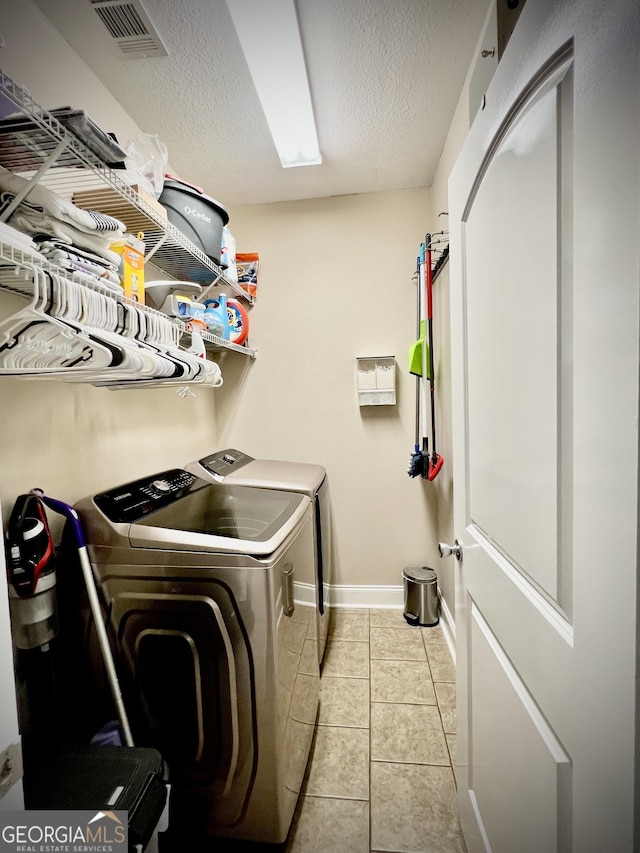 511 Live Oak Way, Dublin, GA 31021 - laundry room featuring washing machine and clothes dryer, a textured ceiling, baseboards, and tile patterned flooring
