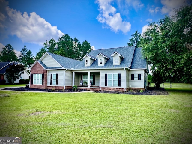 511 Live Oak Way, Dublin, GA 31021 - cape cod-style house with a front lawn, roof with shingles, and covered porch