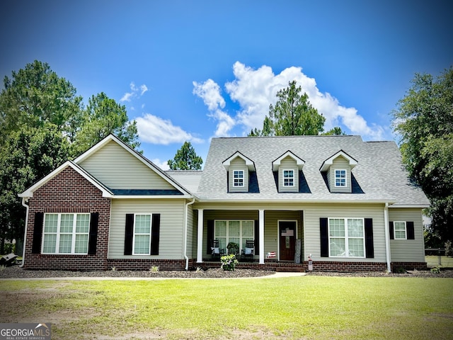 511 Live Oak Way, Dublin, GA 31021 - new england style home featuring covered porch, a front yard, and roof with shingles
