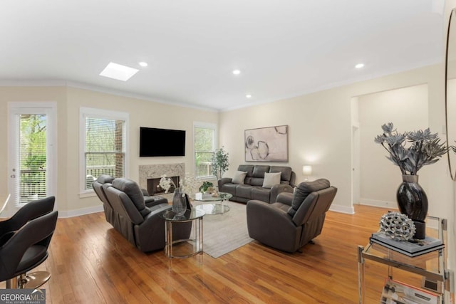 4457 Equity Ct, Ellenwood, GA 30294 - living room featuring crown molding, light wood finished floors, a skylight, a fireplace, and baseboards
