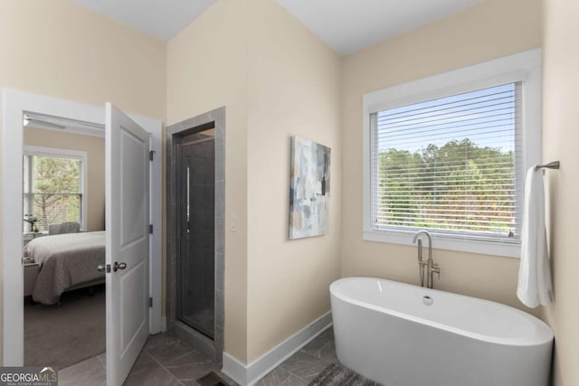 4457 Equity Ct, Ellenwood, GA 30294 - ensuite bathroom featuring marble look tile flooring, plenty of natural light, and a freestanding tub