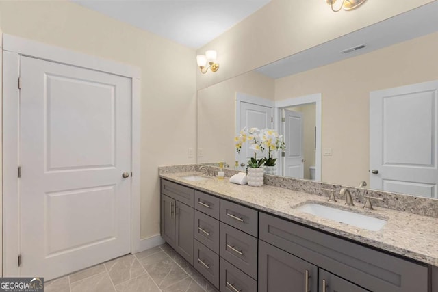 4457 Equity Ct, Ellenwood, GA 30294 - full bath with double vanity, toilet, marble finish floors, and baseboards