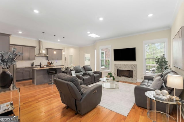 4457 Equity Ct, Ellenwood, GA 30294 - living room with ornamental molding, light wood-style flooring, a fireplace with flush hearth, and recessed lighting