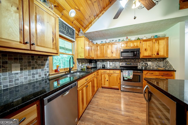 149 Savior Ln, Hamilton, GA 31811 - kitchen featuring stainless steel appliances, a sink, vaulted ceiling, decorative backsplash, and light wood-type flooring