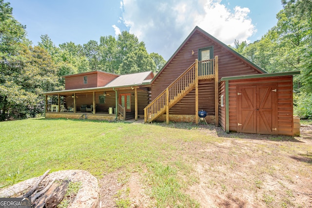149 Savior Ln, Hamilton, GA 31811 - rear view of house featuring a yard, stairs, log exterior, and metal roof