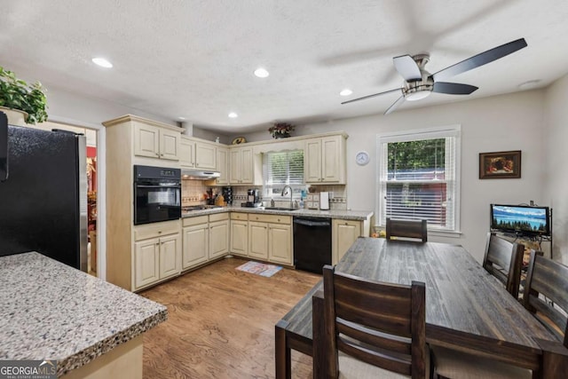 1487 W Bend Creek Ct, Atlanta, GA 30338 - kitchen with black appliances, a sink, cream cabinets, light wood finished floors, and recessed lighting