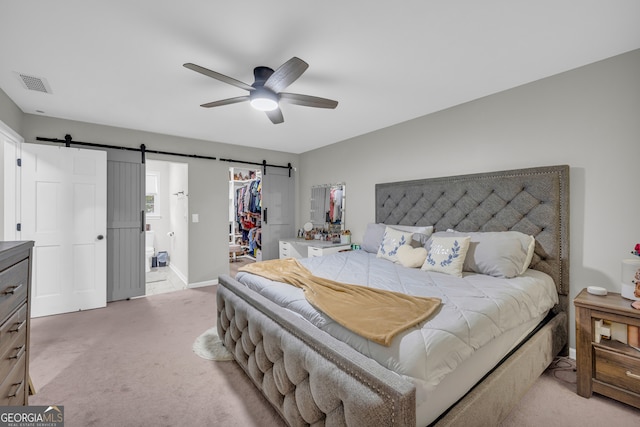 557 Spring Creek Way NE, Marietta, GA 30068 - bedroom featuring a barn door, light colored carpet, a spacious closet, and baseboards