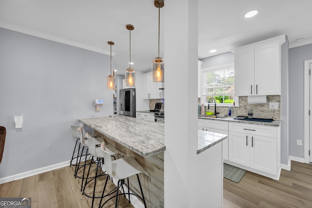 557 Spring Creek Way NE, Marietta, GA 30068 - kitchen with stainless steel refrigerator with ice dispenser, backsplash, light wood-type flooring, a breakfast bar, and white cabinetry