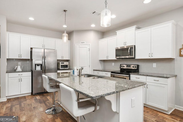 6115 Stella Light Dr, Flowery Branch, GA 30542 - kitchen featuring stainless steel appliances, a sink, white cabinetry, decorative backsplash, and a center island with sink