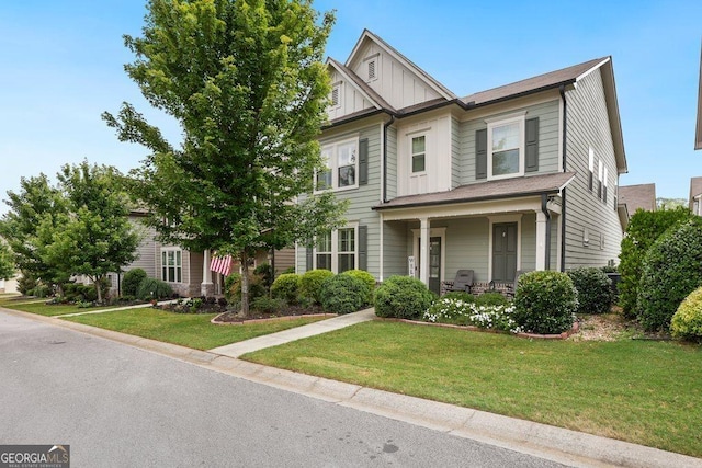 6115 Stella Light Dr, Flowery Branch, GA 30542 - view of front of home featuring board and batten siding, a front lawn, and a porch