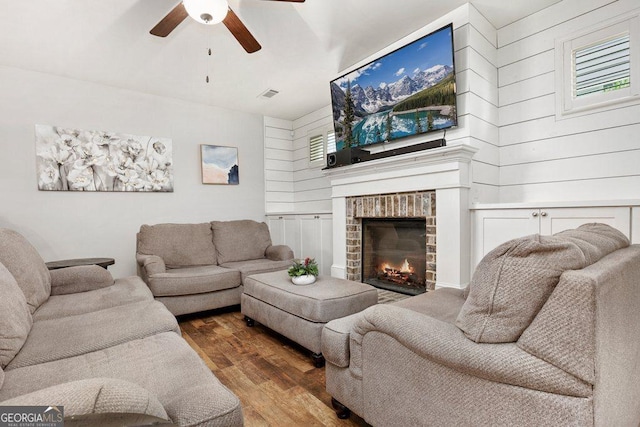 6115 Stella Light Dr, Flowery Branch, GA 30542 - living room featuring wood finished floors, a ceiling fan, and a brick fireplace
