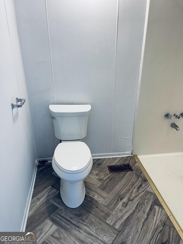 129 E Virginia Ave, Macon, GA 31217 - bathroom with baseboards, toilet, and a shower