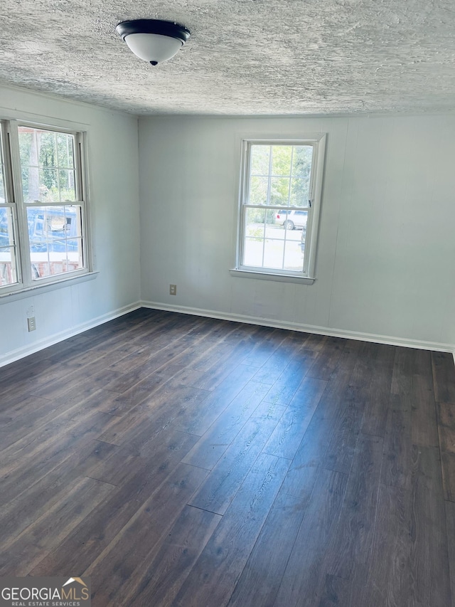 129 E Virginia Ave, Macon, GA 31217 - unfurnished room featuring plenty of natural light, dark wood-style flooring, baseboards, and a textured ceiling