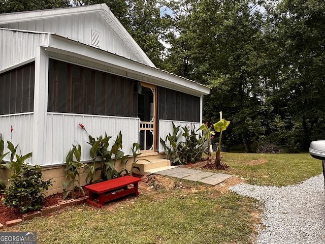 44 Freeman, Heflin, AL 36264 - view of home's exterior with a sunroom, a yard, and view of wooded area